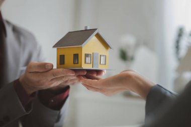 Emlakçılar, konut modellerini müşterilere ayrıntılı bir şekilde anlatma, evler ve satın alma kredileri hakkında bilgi verme ve sunma konularında açıklar. Gayrimenkul ticareti.