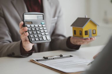 Real estate agents explain models of housing estates in projects to elaborate to clients, explaining and presenting information about homes and purchasing loans. Real estate trading concept.