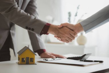 Konut acenteleri anlaşma tamamlandıktan sonra müşterilerle el sıkışıyor, evler ve satın alma kredileri hakkında bilgi veriyor ve sunuyorlar. Gayrimenkul ticareti.