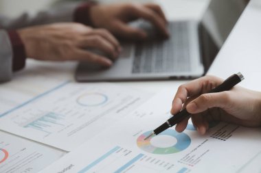 The sales department is having a monthly summary meeting to bring it to the department manager, they are verifying the correctness of the documents that are prepared before bringing in to the manager