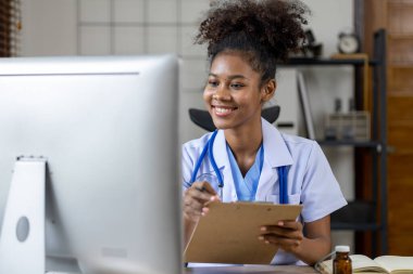 Amerikalı bir kadın doktor hastane ofisinde çalışıyor, kadın bir hekimin hastalıklarını tedavi eden pratisyen hekim ve dahiliye hastasıdır. Tıbbi konsept ve tedavi.