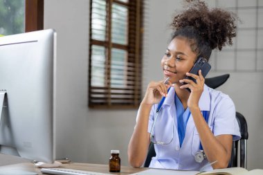 Amerikalı bir kadın doktor telefonda konuşuyor, kendisi pratisyen hekim ve iç hastalıkları tedavi eden bir kadın doktor. Tıbbi konsept ve tedavi.