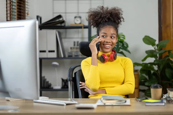 若いアメリカ人女性は起業家であり 彼女は彼女のオフィスに座って 新しい世代のパートナー 経営者 ビジネスと電話で話します スタートアップ経営の考え方 — ストック写真