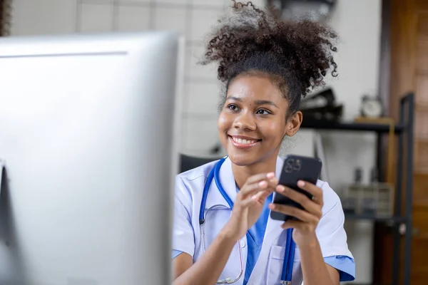 stock image An American female doctor is using a mobile phone, she is a general practitioner and internal medicine patient, treating diseases by a female doctor. Medical concept and treatment.