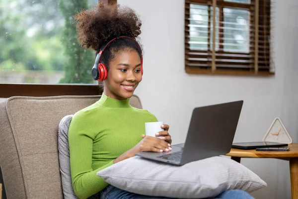 An American teenage woman is in the living room, she is spending her weekends at home playing social media and watching movies. The concept of living on vacation.