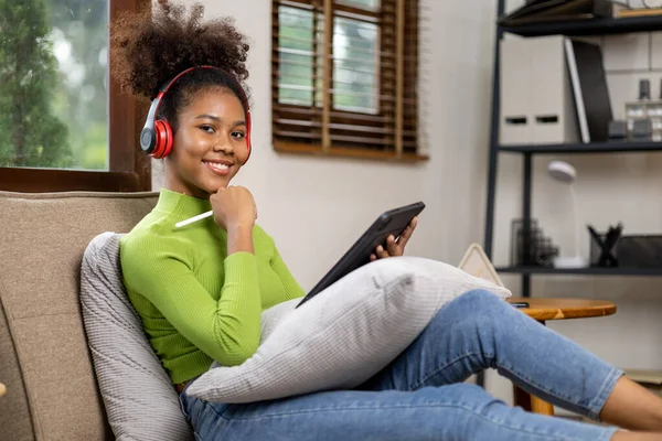 stock image An American teenage woman is in the living room, she is spending her weekends at home playing social media and watching movies. The concept of living on vacation.