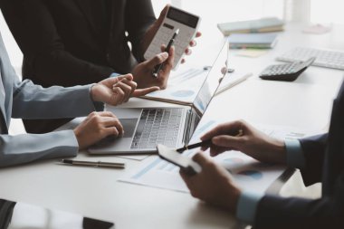 Businessman is reviewing monthly sales documents for analysis and marketing plans for more sales growth, they are the founders of young companies co-founding startups. Sales management concept.