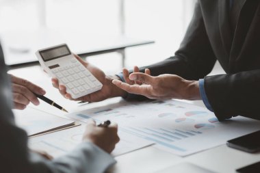 Businessman is reviewing monthly sales documents for analysis and marketing plans for more sales growth, they are the founders of young companies co-founding startups. Sales management concept.