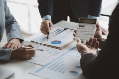 Businessman is reviewing monthly sales documents for analysis and marketing plans for more sales growth, they are the founders of young companies co-founding startups. Sales management concept.