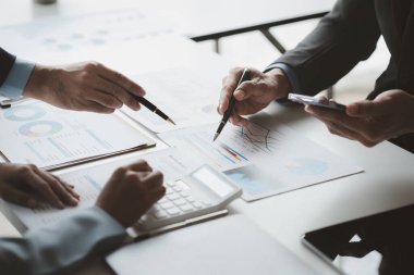 Businessman is reviewing monthly sales documents for analysis and marketing plans for more sales growth, they are the founders of young companies co-founding startups. Sales management concept.