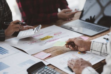 Company meeting room has businessmen and finance managers meeting together on finance topics, they are looking at information on documents and discussing together. Concept company financial management