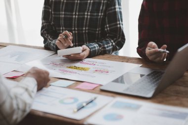 Company meeting room has businessmen and finance managers meeting together on finance topics, they are looking at information on documents and discussing together. Concept company financial management