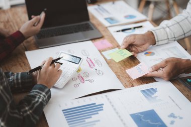 Company meeting room has businessmen and finance managers meeting together on finance topics, they are looking at information on documents and discussing together. Concept company financial management
