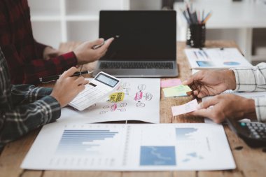 Company meeting room has businessmen and finance managers meeting together on finance topics, they are looking at information on documents and discussing together. Concept company financial management