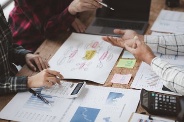 Company meeting room has businessmen and finance managers meeting together on finance topics, they are looking at information on documents and discussing together. Concept company financial management
