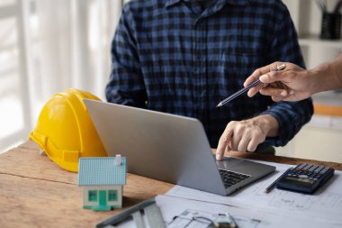 Grup mimarları ve mühendisleri, bina ve inşaat standartlarını karşılamak için ev tasarımlarını tartışmak ve teftiş etmek üzere toplantıdalar. İç tasarım ve dekorasyon fikirleri.