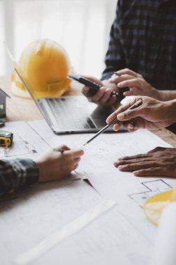 Grup mimarları ve mühendisleri, bina ve inşaat standartlarını karşılamak için ev tasarımlarını tartışmak ve teftiş etmek üzere toplantıdalar. İç tasarım ve dekorasyon fikirleri.