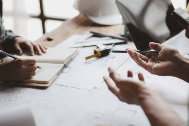 Grup mimarları ve mühendisleri, bina ve inşaat standartlarını karşılamak için ev tasarımlarını tartışmak ve teftiş etmek üzere toplantıdalar. İç tasarım ve dekorasyon fikirleri.