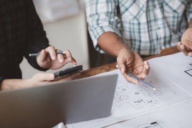 Grup mimarları ve mühendisleri, bina ve inşaat standartlarını karşılamak için ev tasarımlarını tartışmak ve teftiş etmek üzere toplantıdalar. İç tasarım ve dekorasyon fikirleri.
