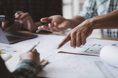 Grup mimarları ve mühendisleri, bina ve inşaat standartlarını karşılamak için ev tasarımlarını tartışmak ve teftiş etmek üzere toplantıdalar. İç tasarım ve dekorasyon fikirleri.