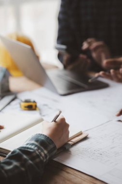 Grup mimarları ve mühendisleri, bina ve inşaat standartlarını karşılamak için ev tasarımlarını tartışmak ve teftiş etmek üzere toplantıdalar. İç tasarım ve dekorasyon fikirleri.