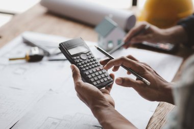 The home design architects are reviewing the house plan draft, the project commissioned by the client, and the custom design before delivery. Interior design and decoration ideas.