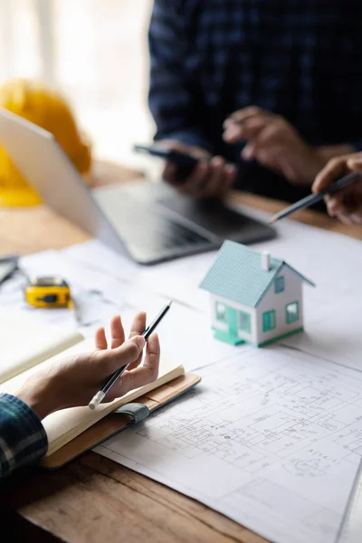 Group architects and engineers are in a meeting to discuss and inspect the house designs to meet the building and construction standards. Interior design and decoration ideas.