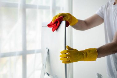 Temizlik odası, temizlik işçisi şirket ofisindeki bilgisayar ekranını silmek için bez kullanıyor. Temizlik personeli. Örgütteki temizlik kavramı.