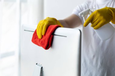 Temizlik odası, temizlik işçisi şirket ofisindeki bilgisayar ekranını silmek için bez kullanıyor. Temizlik personeli. Örgütteki temizlik kavramı.