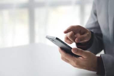 Akıllı telefondan sosyal medyayı kullanmak için cep telefonu tutan bir kişi, akıllı telefondan internet üzerinden iletişim kuruyor. İletişim için teknolojiyi kullanma kavramı.