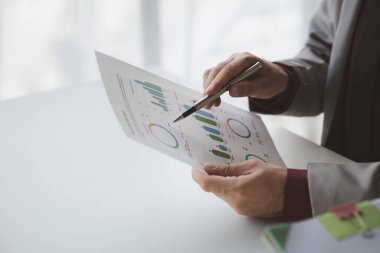 Finansörlerden biri şirketin mali belgelerini inceliyor. Finans departmanından aylık hesap özeti. Şirketin doğruluk ve büyüme finansmanını yönetme kavramı.