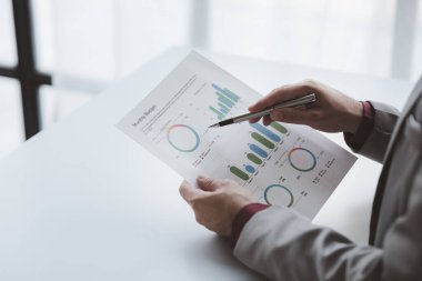 Finansörlerden biri şirketin mali belgelerini inceliyor. Finans departmanından aylık hesap özeti. Şirketin doğruluk ve büyüme finansmanını yönetme kavramı.