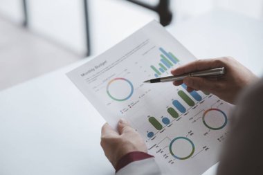 Finansörlerden biri şirketin mali belgelerini inceliyor. Finans departmanından aylık hesap özeti. Şirketin doğruluk ve büyüme finansmanını yönetme kavramı.