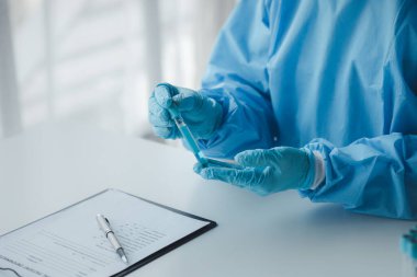 Lab assistant, a medical scientist, a chemistry researcher holds a glass tube through the blood sample, does a chemical experiment and examines a patient's blood sample. Medicine and research concept.