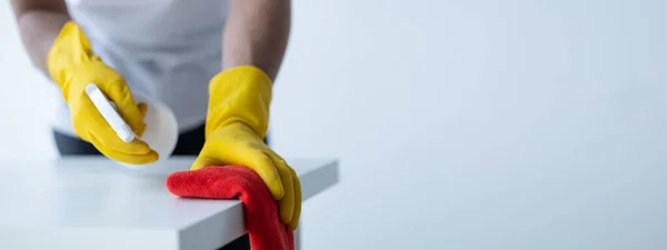 stock image Person cleaning the room, cleaning staff is using cloth and spraying disinfectant to wipe the table in the company office room. Cleaning staff. Maintaining cleanliness in the organization.