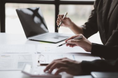 The sales department is having a monthly summary meeting to bring it to the department manager, they are verifying the correctness of the documents that are prepared before bringing in to the manager