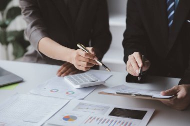 Businessman is reviewing monthly sales documents for analysis and marketing plans for more sales growth, they are the founders of young companies co-founding startups. Sales management concept.