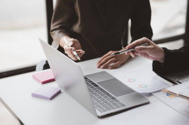 Businessman is reviewing monthly sales documents for analysis and marketing plans for more sales growth, they are the founders of young companies co-founding startups. Sales management concept.