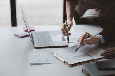 Businessman is reviewing monthly sales documents for analysis and marketing plans for more sales growth, they are the founders of young companies co-founding startups. Sales management concept.