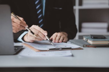 Businessman is reviewing monthly sales documents for analysis and marketing plans for more sales growth, they are the founders of young companies co-founding startups. Sales management concept.