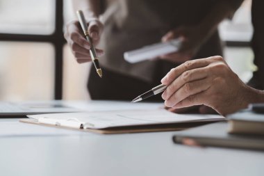 Businessman is reviewing monthly sales documents for analysis and marketing plans for more sales growth, they are the founders of young companies co-founding startups. Sales management concept.