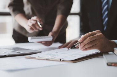 Businessman is reviewing monthly sales documents for analysis and marketing plans for more sales growth, they are the founders of young companies co-founding startups. Sales management concept.