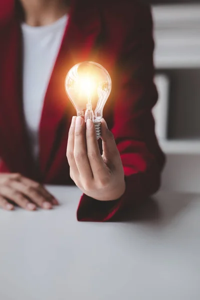 Person holding glowing lamp, Creative new idea. Innovation, brainstorming, strategizing to make the business grow and be profitable. Concept execution, strategy planning and profit management.