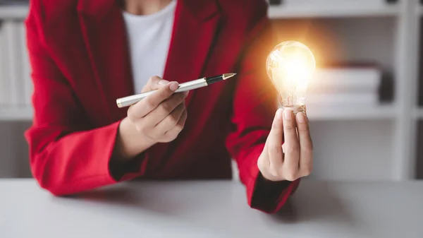 Person holding glowing lamp, Creative new idea. Innovation, brainstorming, strategizing to make the business grow and be profitable. Concept execution, strategy planning and profit management.