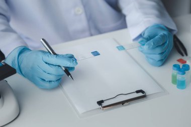 Laboratuvar asistanı, tıp bilimcisi, kimya araştırmacısı kimyasal test tüpünden cam bir tüp tutuyor, kimyasal deney yapıyor ve hastanın örneğini inceliyor. Tıp ve araştırma konsepti.