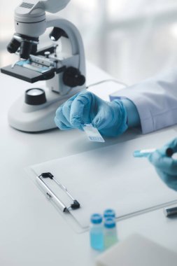 Laboratuvar asistanı, tıp bilimcisi, kimya araştırmacısı kimyasal test tüpünden cam bir tüp tutuyor, kimyasal deney yapıyor ve hastanın örneğini inceliyor. Tıp ve araştırma konsepti.