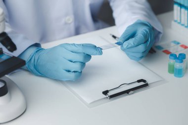 Laboratuvar asistanı, tıp bilimcisi, kimya araştırmacısı kimyasal test tüpünden cam bir tüp tutuyor, kimyasal deney yapıyor ve hastanın örneğini inceliyor. Tıp ve araştırma konsepti.