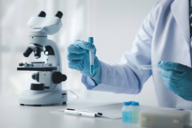 Laboratuvar asistanı, tıp bilimcisi, kimya araştırmacısı kimyasal test tüpünden cam bir tüp tutuyor, kimyasal deney yapıyor ve hastanın örneğini inceliyor. Tıp ve araştırma konsepti.