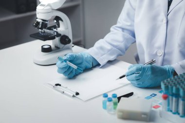 Laboratuvar asistanı, tıp bilimcisi, kimya araştırmacısı kimyasal test tüpünden cam bir tüp tutuyor, kimyasal deney yapıyor ve hastanın örneğini inceliyor. Tıp ve araştırma konsepti.