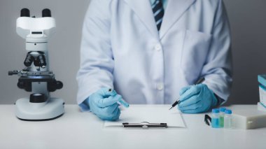 Laboratuvar asistanı, tıp bilimcisi, kimya araştırmacısı kimyasal test tüpünden cam bir tüp tutuyor, kimyasal deney yapıyor ve hastanın örneğini inceliyor. Tıp ve araştırma konsepti.